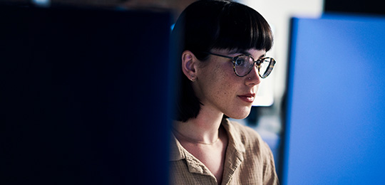 Person with glasses looking at a screen