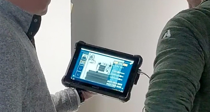 Two people looking at SharpLogixx app on a tablet